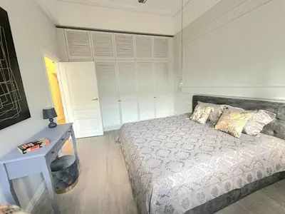 a bedroom with a bed and a desk and a window at Apartamentai Bazilijonai in Vilnius