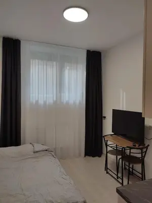 a bedroom with a bed and a desk with a television at GoodStopCenter in Vilnius