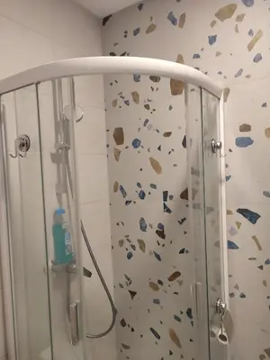 a bathroom with a shower with a rock wall at GoodStopCenter in Vilnius