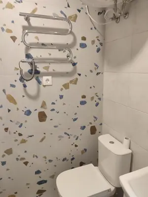 a bathroom with a toilet and a wall with hearts at GoodStopCenter in Vilnius