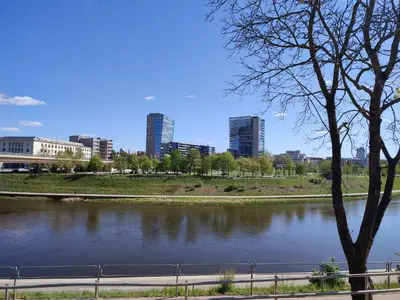 a view of a river with buildings in the background at ShortStopStudent in Vilnius