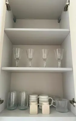a shelf with wine glasses and bowls on it at Small but with character in Kaunas