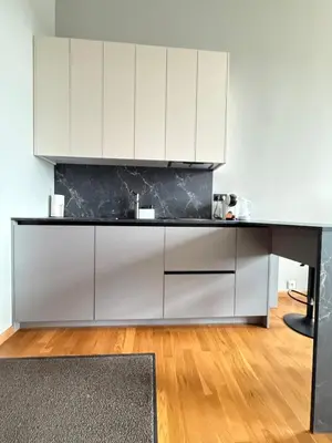 a kitchen with white cabinets and a black counter top at Small but with character in Kaunas
