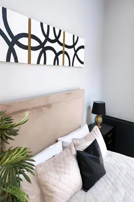 a bedroom with a bed with black and white pillows at Elumen Studio Apartment I near Cathedral & Bernardine Park in Vilnius