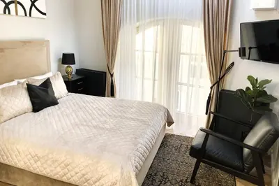 a bedroom with a bed and a television and a chair at Elumen Studio Apartment I near Cathedral & Bernardine Park in Vilnius