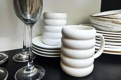 a table with a white vase and a wine glass at Elumen Studio Apartment I near Cathedral & Bernardine Park in Vilnius