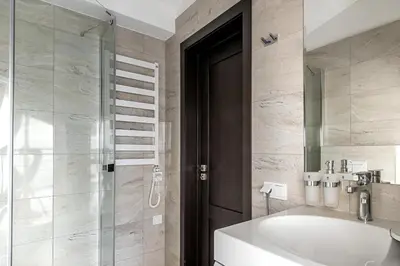 a bathroom with a shower and a tub and a sink at Elumen Studio Apartment I near Cathedral & Bernardine Park in Vilnius