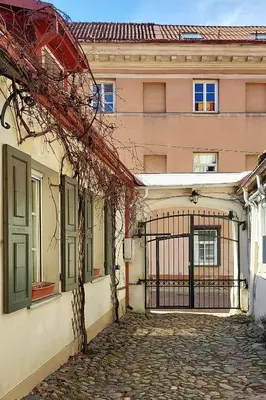 a gate on the side of a building at Elumen Studio Apartment I near Cathedral & Bernardine Park in Vilnius