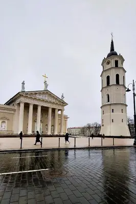 a building with a clock tower and a church at Elumen Studio Apartment I near Cathedral & Bernardine Park in Vilnius