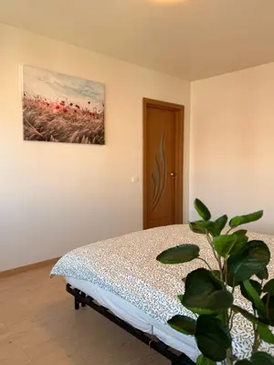 a bedroom with a bed and a painting on the wall at Apartamentai Jonavoje #2 in Jonava