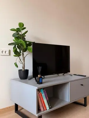 a white entertainment center with a flat screen tv on it at Apartamentai Jonavoje #2 in Jonava