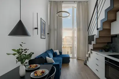 a living room with a blue couch and a staircase at Loft 60 with Free parking in Vilnius