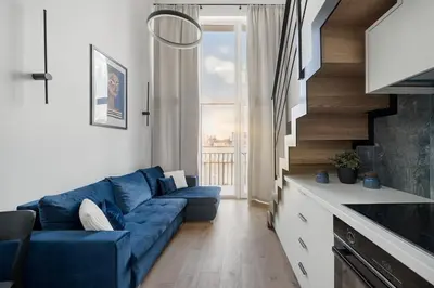 a living room with a blue couch in front of a window at Loft 60 with Free parking in Vilnius