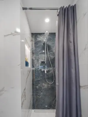 a shower with a gray shower curtain in a bathroom at Loft 60 with Free parking in Vilnius