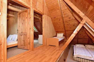 an attic room with two beds in a wooden house at Namas su vaizdu į ežerą 