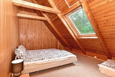 an attic room with a bed and a window at Namas su vaizdu į ežerą 