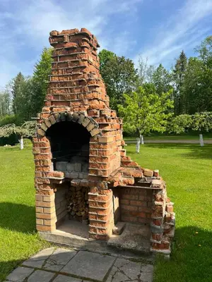 an outdoor brick oven in a grass field at Namas su vaizdu į ežerą 