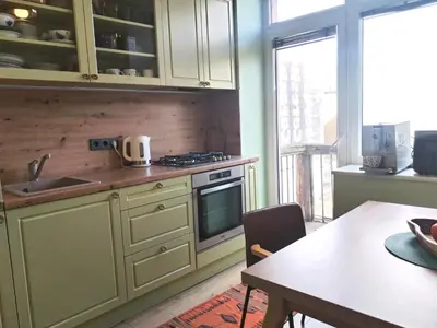 a kitchen with a sink and a stove and a table at Heart of Kaunas Apartament in Kaunas