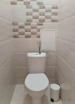 a bathroom with a white toilet with a picture on the wall at Heart of Kaunas Apartament in Kaunas