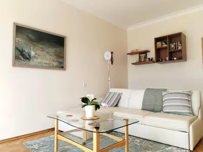 a living room with a white couch and a table at Heart of Kaunas Apartament in Kaunas