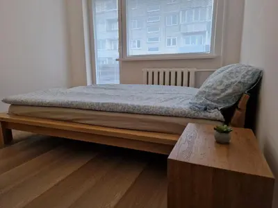 a bed in a room with a table and a window at Close to Park in Kaunas