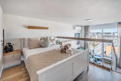 a bedroom with a large bed with a balcony at Modern Studio near the city center in Vilnius