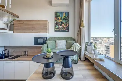 a living room with a table and a couch at Modern Studio near the city center in Vilnius
