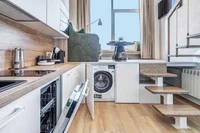 a kitchen with a washer and dryer in it at Modern Studio near the city center in Vilnius