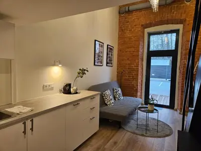 a kitchen with a counter and a couch in a room at Loft in Freda in Kaunas