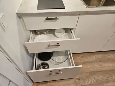 a kitchen with white drawers and a counter at Loft in Freda in Kaunas