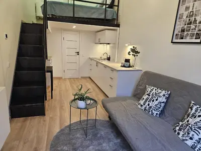 a living room with a couch and a loft bed at Loft in Freda in Kaunas