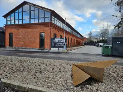 a large brick building with a large metal object in front of it at Loft in Freda in Kaunas