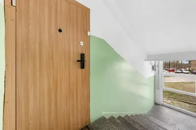 a wooden door in a room with a staircase at Bright, cozy apartment 5 min walk to Old town in Vilnius