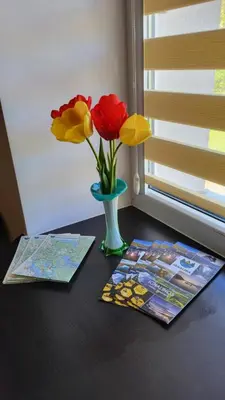a table with a vase with flowers and magazines at Patogus poilsis in Ignalina