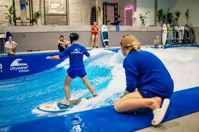 a man on a surfboard in a fake wave at citywave Vilnius in Vilnius
