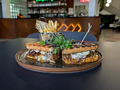a plate with two sandwiches and french fries on a table at citywave Vilnius in Vilnius