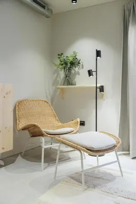 a rattan chair and a stool in a living room at citywave Vilnius in Vilnius