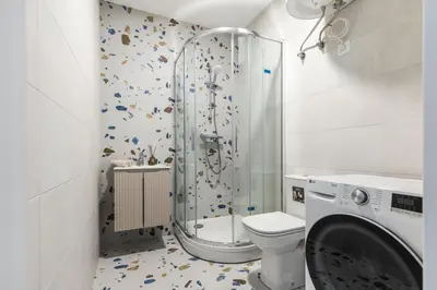 a bathroom with a shower and a washing machine at Fox Rock Studio - Self check in in Vilnius