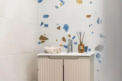 a bathroom with a white sink and blue rocks on the wall at Fox Rock Studio - Self check in in Vilnius
