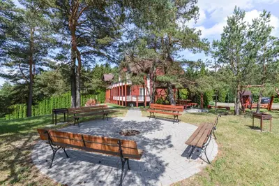 a group of benches sitting in a park at Nakvynė prie ežero Akmenėlis in Dyviliškiai