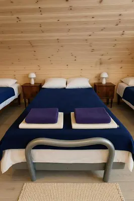 a bedroom with a bed with three pillows on it at Apartamentai in Veisiejai