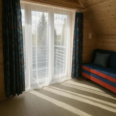 a window in a room with a couch next to a window at Apartamentai in Veisiejai