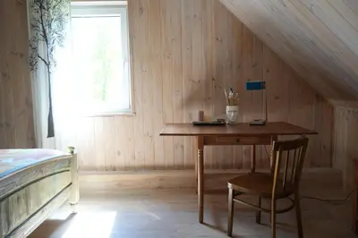 a wooden room with a table and a bed at Molinis ir Medinis in Ažuluokesa