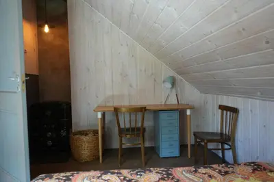 a room with a desk and two chairs and a bed at Molinis ir Medinis in Ažuluokesa