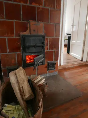 a brick wall with a stove in a room at Namelis 1954 in Švenčionėliai