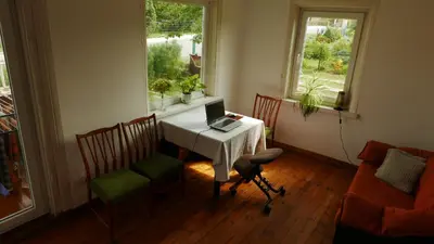 a dining room with a table with a laptop on it at Namelis 1954 in Švenčionėliai