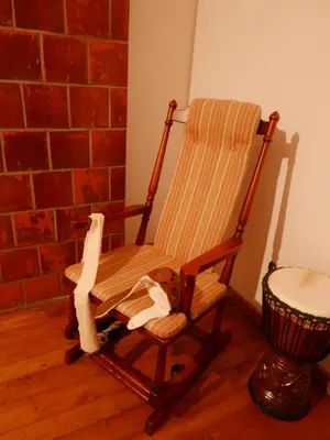 a rocking chair in a room with a brick wall at Namelis 1954 in Švenčionėliai
