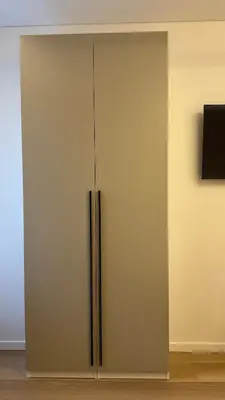 a white cabinet with a tv on a wall at EVA boutique apartments in Vilnius