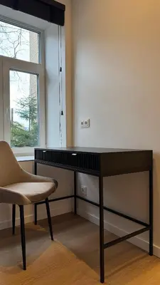 a desk in a room with a chair and a window at EVA boutique apartments in Vilnius