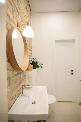 a white bathroom with a sink and a mirror at Lukiškės Central Apartment - Self Check-in and Parking Option in Vilnius